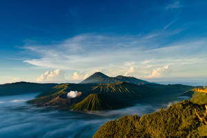黎明時分，火山山峰聳立在雲海之上 — 黎明 壁紙