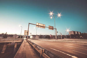 黃昏時分空無一人的高速公路，發光的街燈和模糊的汽車軌跡。 — 淺棕色美學 壁紙
