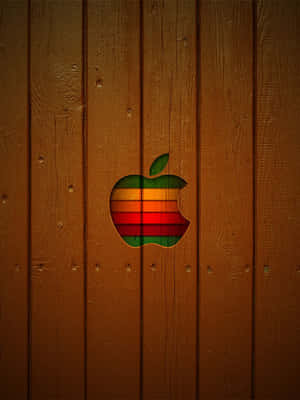 彩虹Apple標誌切割在木板上，帶有可見的木紋。