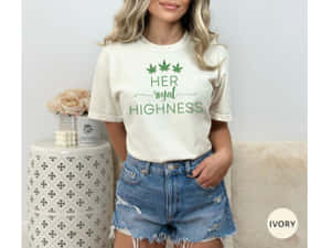 女性穿著奶油色T恤，上有綠色royal highness文字和葉子設計，搭配破洞牛仔短褲。