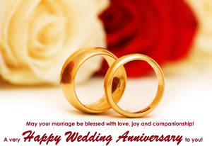 兩枚金色結婚戒指，搭配紅玫瑰和奶油色玫瑰以及週年紀念問候文字。