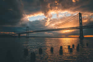 金色夕陽下，帶有戲劇性烏雲的水上吊橋