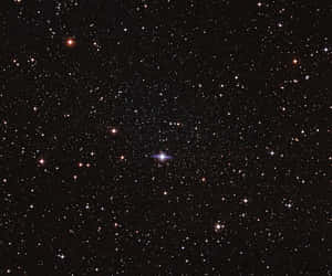 一個繁星點點的夜空，有一顆明亮的藍白色星星和無數其他星星。