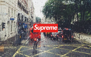 汽車車窗上的雨滴，望向城市交通中的紅色雙層巴士和Supreme標誌。