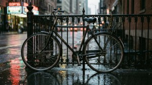 復古單車停喺夜晚濕咗嘅城市街道上，帶有霓虹倒影。 — 自行車 壁紙