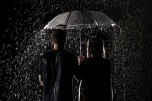 兩人在夜間大雨中一起撐傘。 — 情侶 GIF 壁紙