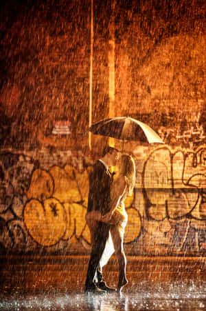情侶在雨中傘下接吻，夜間塗鴉牆 — 情侶 GIF 壁紙