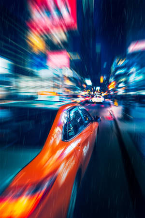 橙色出租車在夜間雨中的霓虹城市中疾馳，帶有動態模糊。 — 夜景城市 壁紙