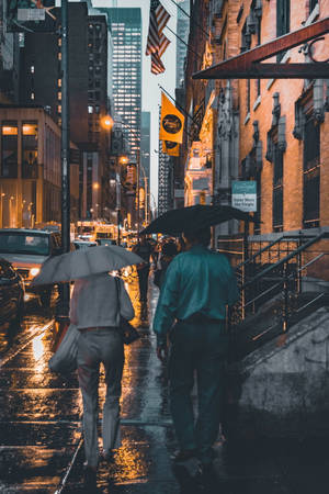 兩個人在夜晚的城市街道上撐傘雨中行走