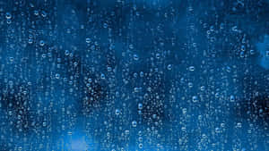雨滴在玻璃窗上滑落，背景是藍色天空。 — 雨天 壁紙