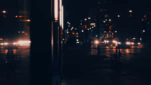 夜間城市街道，車燈模糊，濕漉漉的路面反射。 — 夜景城市 壁紙