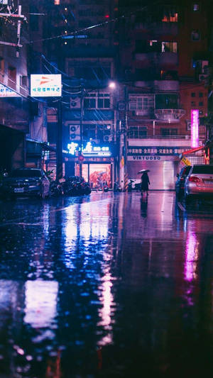 夜晚在潮濕的城市街道上，人在霓虹燈下雨中行走。