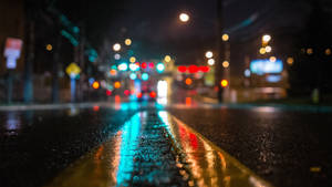 雨夜街道，模糊的交通燈光反射在潮濕的路面上。