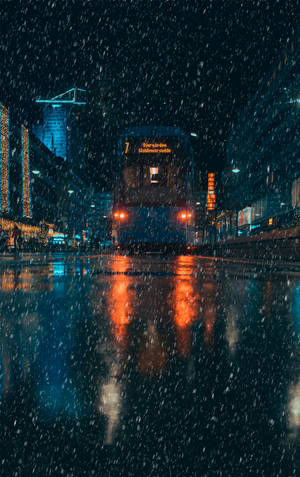 雪花飄落在濕漉漉的城市街道上，一輛電車帶著發光的紅燈駛近。