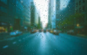 窗戶上的雨滴，俯瞰夜晚模糊的城市街道。