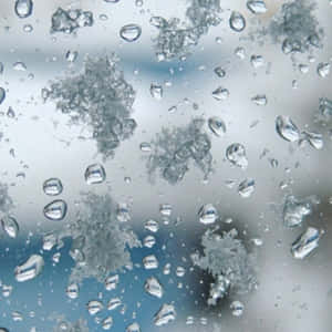 窗上的雨滴和霜，背景為模糊的天空。