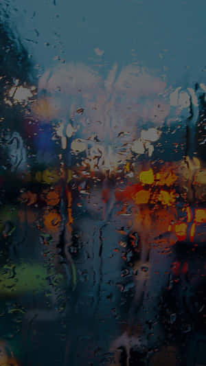 雨點在窗戶上流動，顯示夜間模糊的城市燈光。