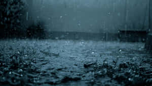 雨滴在濕漉漉的路面上飛濺，呈現暴風雨般的藍灰色場景。