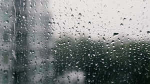 窗上的雨滴與模糊的城市背景