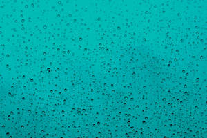 透過濺滿雨水的玻璃看到的青綠色天空