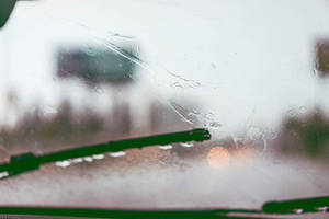 汽車擋風玻璃上的雨滴，雨刷在濕玻璃上移動。