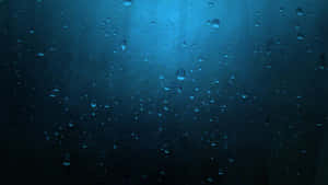 夜晚，藍光照亮窗戶上的雨滴。