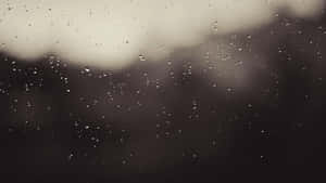 玻璃窗上的雨滴，背後有模糊的灰色天空和黑暗的景色。 — 美學圖案 壁紙