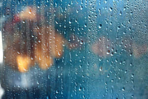 窗戶上的雨滴，外面模糊的暖色燈光。 — 雨天 壁紙