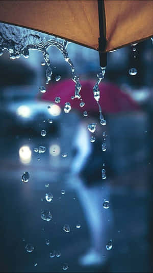 雨夜城市中從雨傘落下的雨滴。 — 雨天 壁紙