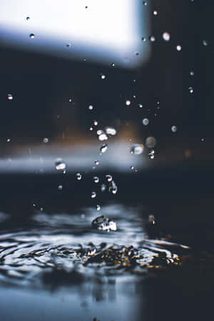 雨點濺入水中產生漣漪和飛濺的水滴。