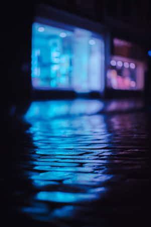 濕漉漉的鵝卵石街道在夜晚反射藍色霓虹燈光。 — 霓虹藍色美學 壁紙