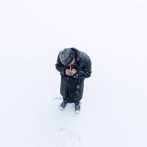 雪中持點燃蠟燭的人