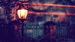 夜晚雪中發光的路燈，模糊的城市背景。