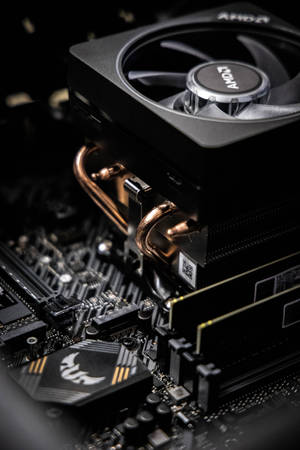 AMD CPU 散熱器和主機板特寫，帶有銅管和發光標誌。