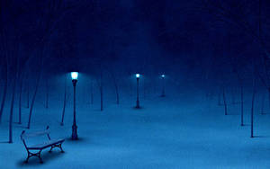 雪地公園長椅在發光的街燈下，夜晚有飄雪。 — 冬日美學 壁紙