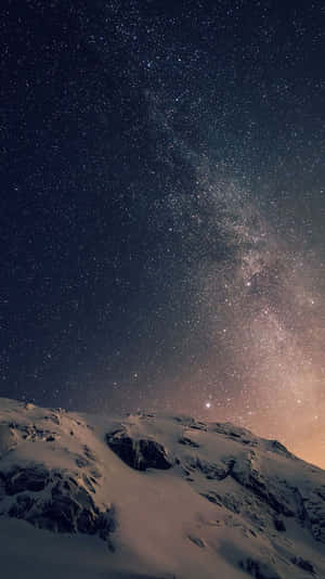 白雪覆蓋的山，在繁星點點的夜空下，銀河可見。