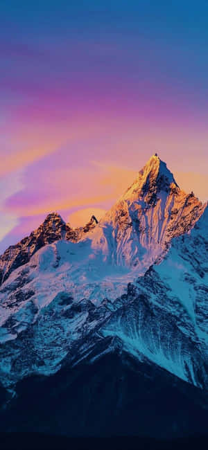 在紫色天空下，被金色夕陽沐浴的雪山峰。