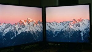 兩個電腦顯示器顯示著雪山的日落場景。 — 3840x1080 GIF 壁紙