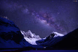 在鮮豔的紫色星空和銀河下的雪山峰頂