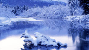 積雪河流，以冷藍色調反射冬日樹木和山脈。