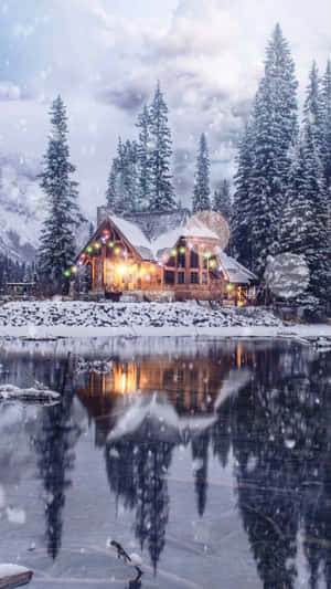 舒適的小屋，溫暖的燈光在結冰的湖中反射，雪黃昏的天空下。 — 美學 壁紙