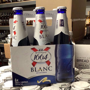 商店貨架上的一組六瓶Kronenbourg 1664 Blanc啤酒。