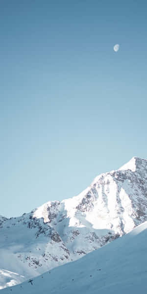 積雪的山峰與晴朗藍天上的新月