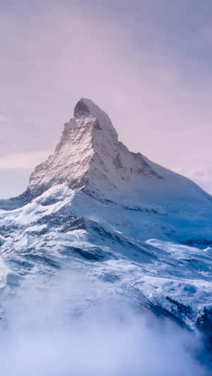黎明時分，白雪覆蓋的馬特洪峰山頂聳立在雲層之上。