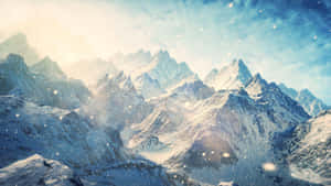明亮的天空下，積雪覆蓋的山脈，雪花飄落。 — 日出 壁紙