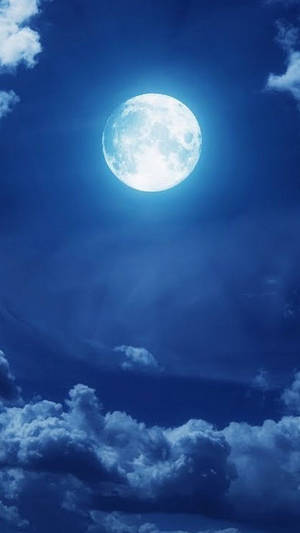 滿月透過雲層在深藍色夜空中閃耀