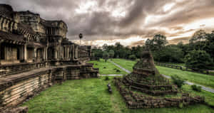 古老寺廟遺跡，石結構和綠草，在多雲的天空下。 — 日產 Skyline GTR R33 壁紙