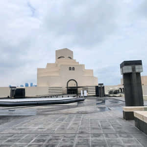 陰天下帶有濕潤石質廣場的現代米色階梯式博物館 — 建築 壁紙