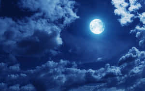 滿月在夜間穿過深藍色雲層閃耀。 — 月色夜空 壁紙