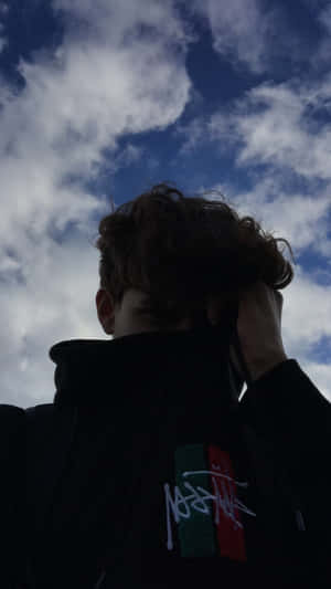 穿連帽衫的人仰望多雲天空 — 唯美雲朵動態 壁紙